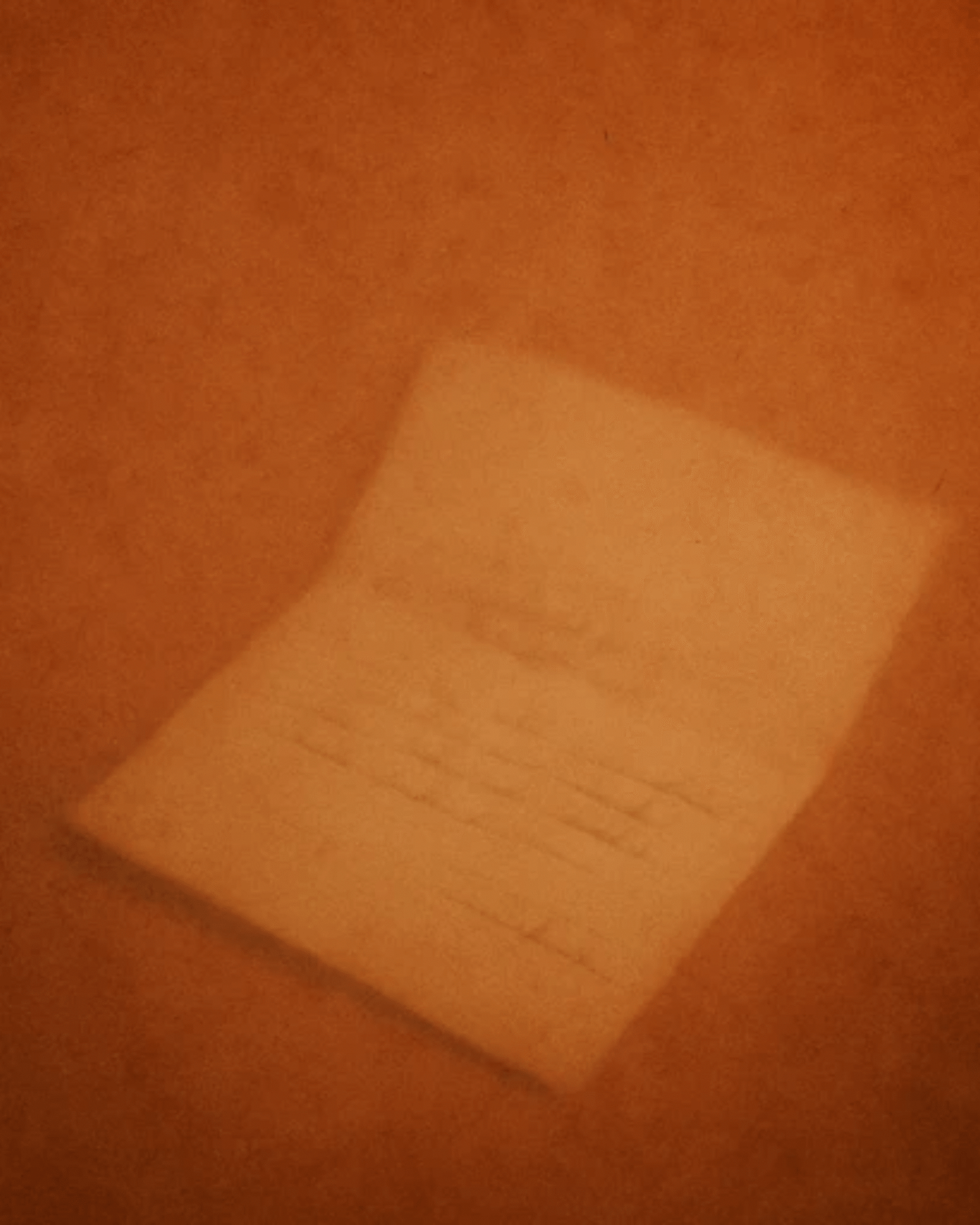 Soft-focus handwritten letter on warm orange background texture