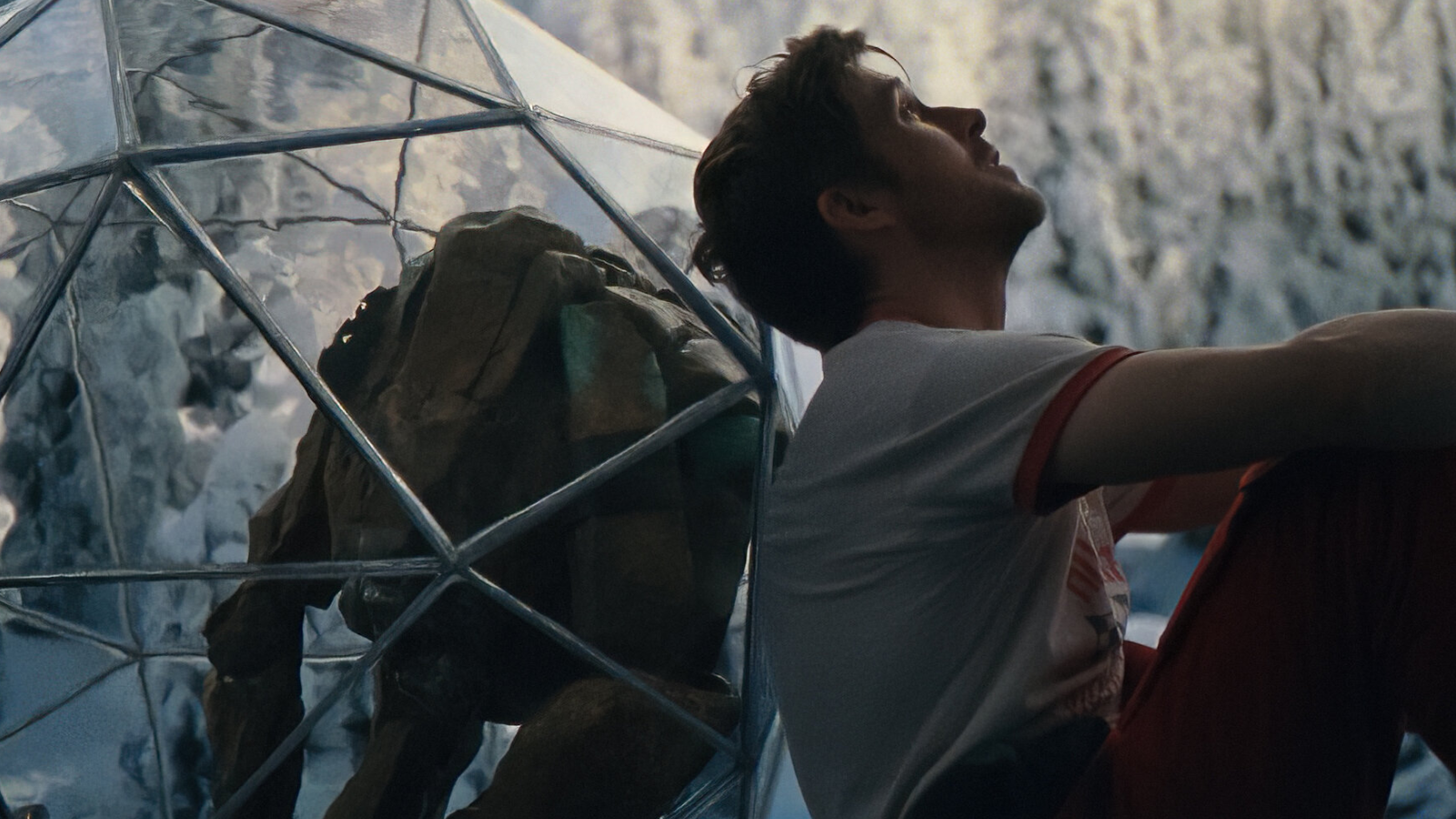 Project Hail Mary (2026) - Ryan Gosling as Ryland Grace sits beside Rocky inside a transparent habitat still